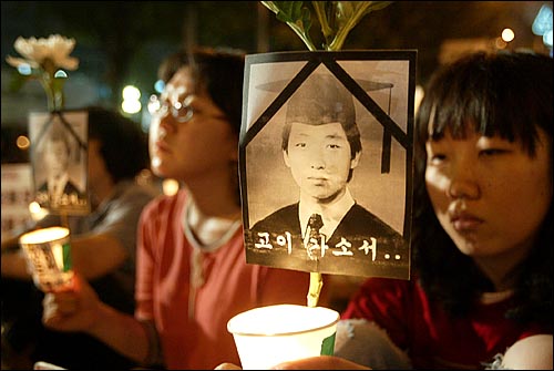 촛불 집회 참가자들이 고 김선일씨를 추모하며 영정사진과 국화꽃을 들고 있다. 